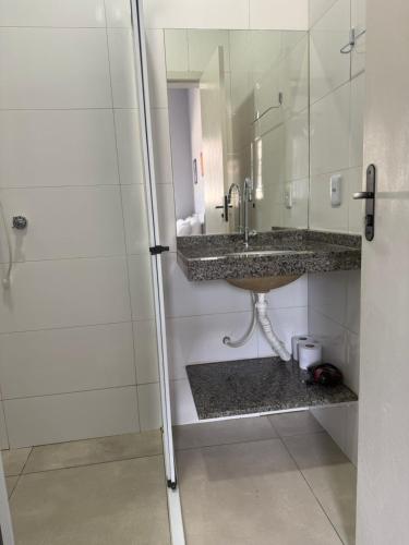 a bathroom with a sink and a mirror at Amazon LOFT 08 in Sorriso