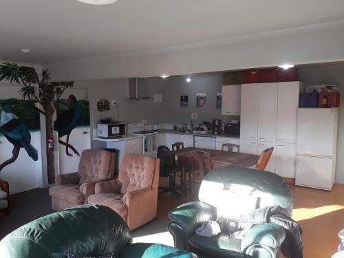 a living room with a couch and chairs and a kitchen at Wellington Vibes in Wellington