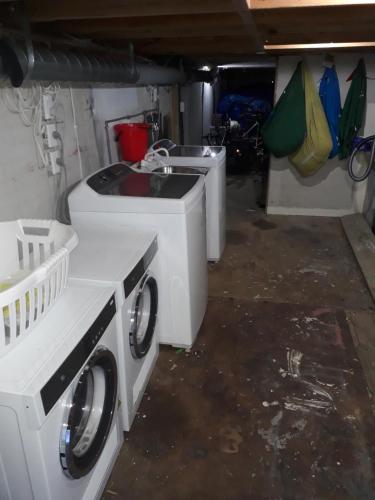 a laundry room with two washing machines and a sink at Wellington Vibes in Wellington