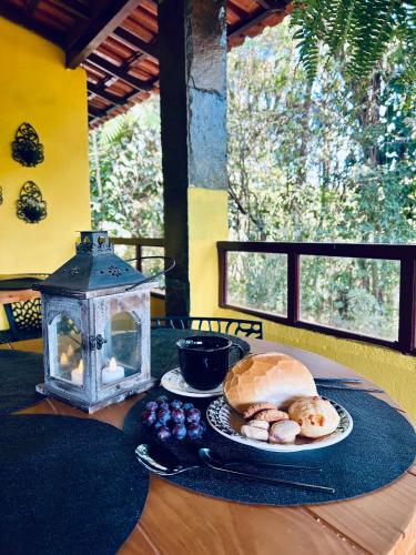a table with a plate of food and a lantern at Hari Eco Pousada in Brumadinho