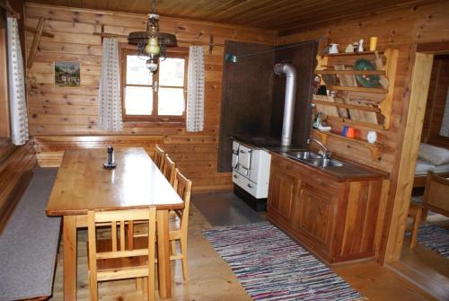 a kitchen in a log cabin with a table and a stove at Fröschlhütte in Oberpirkach