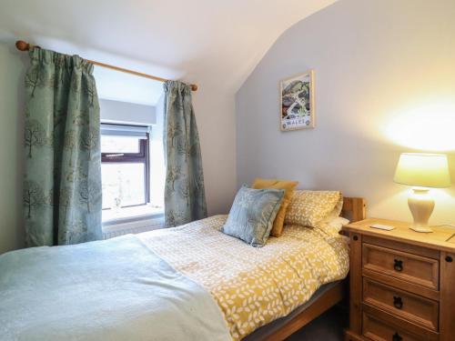 a bedroom with a bed and a window at Old Station Cottage in Blaenau-Ffestiniog