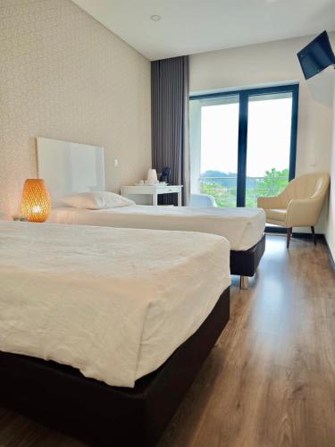 a hotel room with two beds and a window at Quinta do Botas in Moimenta