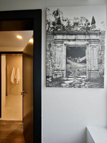 a painting hanging on a wall next to a hallway at Quinta do Botas in Moimenta