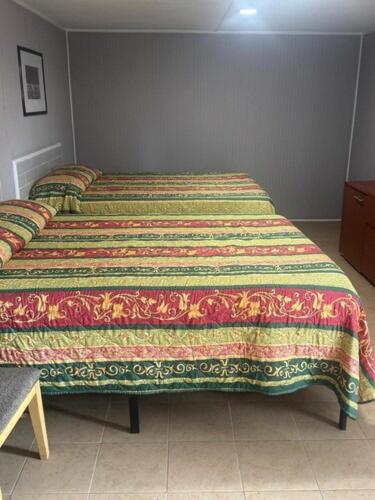 a bedroom with a bed with a colorful blanket on it at Star Motel in Tampa