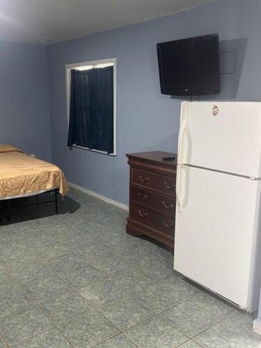 a room with a white refrigerator and a bed at Star Motel in Tampa