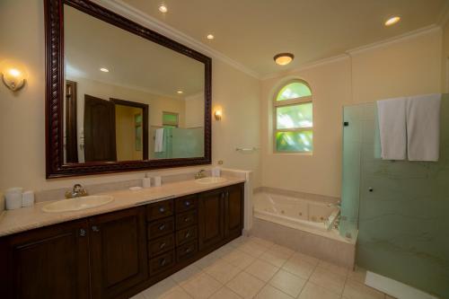 a bathroom with two sinks and a shower and a mirror at Bella Vista 3F 3 bdr beach club view in Los Suenos in Herradura
