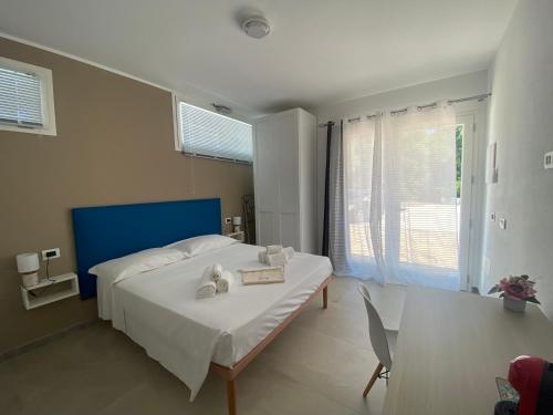 a bedroom with a bed and a table with a book at DOMO DE MARIA in San Teodoro