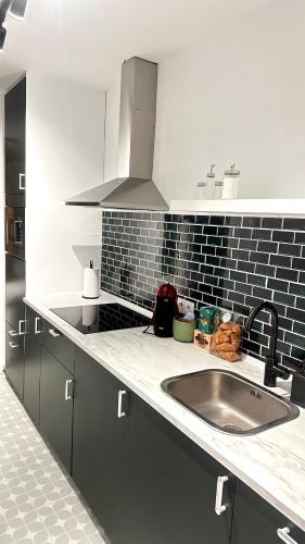 a kitchen with a sink and a counter top at R&R Suite Heritage in León