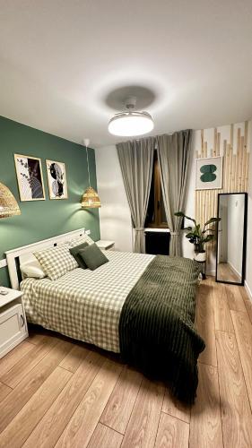 a bedroom with a bed and a green wall at R&R Suite Heritage in León