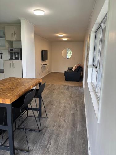 a kitchen and living room with a table and chairs at Coastal Guest Suite near Fishermans Cove in Whangaparaoa