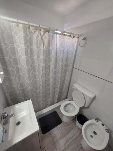 a bathroom with a toilet and a sink and a shower at Depto céntrico de 3 habitaciones y cochera in Rosario