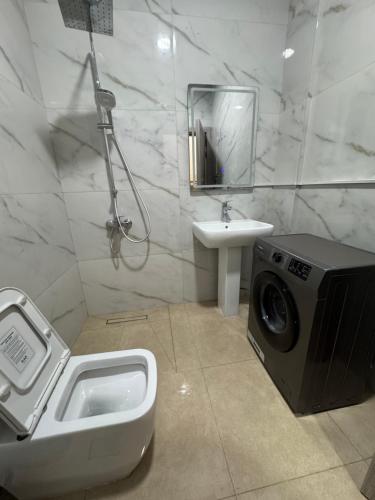 a bathroom with a washing machine and a sink at شروق للاستديوهات المفروشه in Abu Dhabi