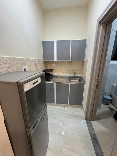 a small kitchen with a sink and a dishwasher at شروق للاستديوهات المفروشه in Abu Dhabi
