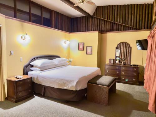 a bedroom with a large bed and a dresser at Riverview Lodge in Dryden