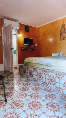 a bedroom with a bed and a tv on the wall at Banpu Beach Ao Lung Dam,Koh Samet in Ao Phutsa