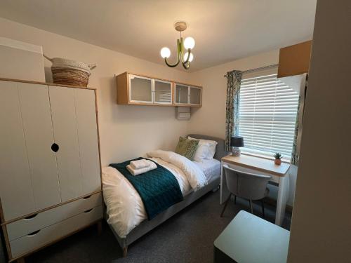 a small bedroom with a bed and a desk at 2 Bedroom Apartment 11 Minutes From Stansted Airport in Great Dunmow
