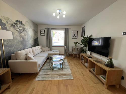 a living room with a couch and a flat screen tv at 2 Bedroom Apartment 11 Minutes From Stansted Airport in Great Dunmow