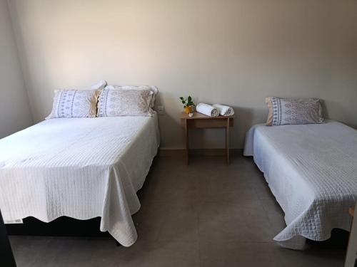 a bedroom with two beds and a side table at Espaço Real in Manhã