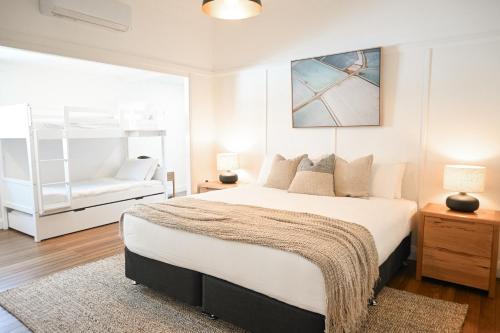 a bedroom with a large bed and a couch at Soluna House in Byron Bay