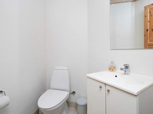 a white bathroom with a toilet and a sink at 8 person holiday home in Læsø in Læsø