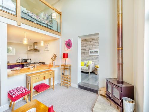 a kitchen with a wood stove and a living room at Hallmark Lodge in Tenterden