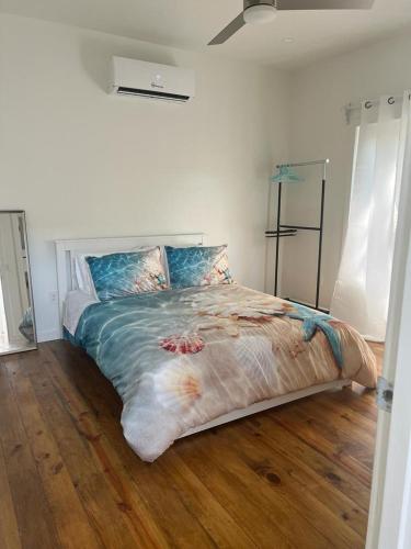a bedroom with a large bed with a wooden floor at Island Time house in Utila
