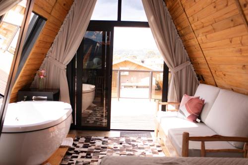 a bathroom with a tub and a toilet and a couch at Pousada Flor do Campestre in Urubici