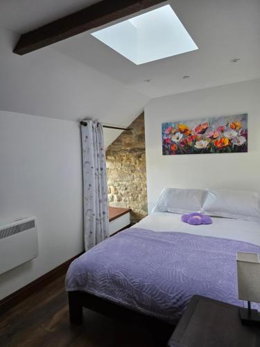 a bedroom with a bed and a painting on the wall at Grawen Fach in Cefn-coed-y-cymmer