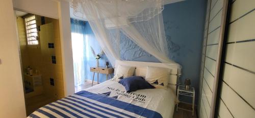 a bedroom with a bed with a canopy at Escale caraibe in Le Gosier