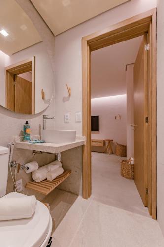 a bathroom with a sink and a mirror at Pousada Aysú in Japaratinga