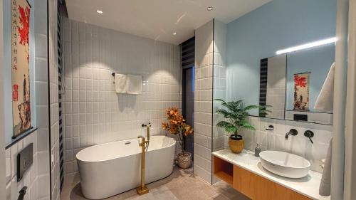 a bathroom with a tub and a sink and a mirror at Villa #40, Ambassadori Kachreti Golf Resort in Kachretʼi