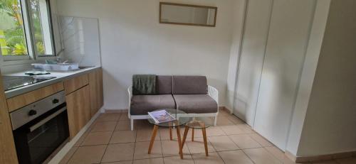 a kitchen with a chair and a table in it at Les Gîtes Blue Karaib in Sainte-Anne