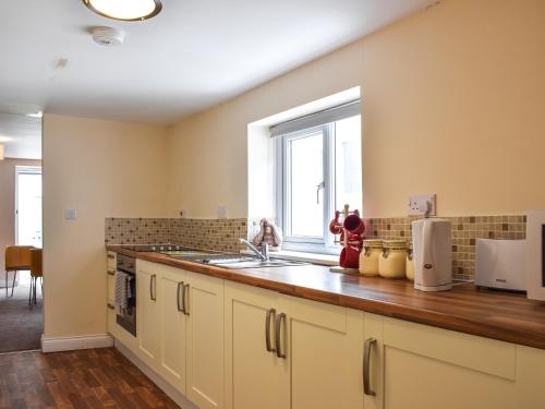 a kitchen with a sink and a window at Winnies Cottage in Belford