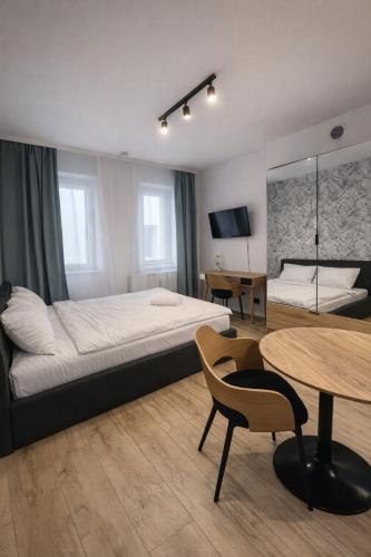 a bedroom with a large bed and a table at HostLoop Apartments - Świętego Pawła 10 in Katowice