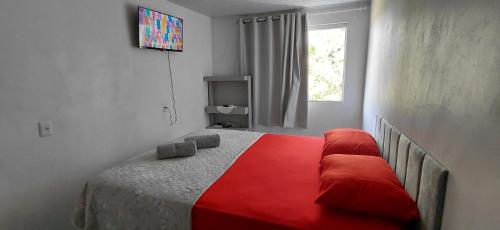 a bedroom with a bed with a red blanket at Chalé canto do bugiu in Rio do Sul