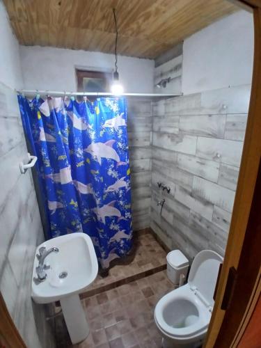 a bathroom with a sink and a toilet and a shower curtain at Hospedaje Abiel in El Mollar