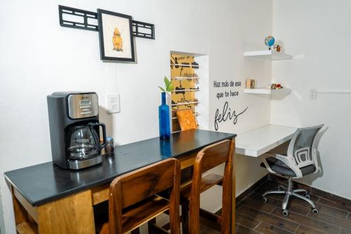 a desk with a coffee maker and chairs in a room at Rincón pochutleco in San Pedro Pochutla