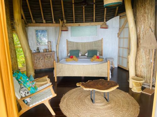 a bedroom with a bed and a table in it at Raiatea Treelodge in Taoru