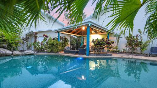 a swimming pool in front of a house at Trinity Beach Pacific in Trinity Beach
