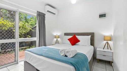 a bedroom with a large bed with towels on it at Trinity Beach Pacific in Trinity Beach