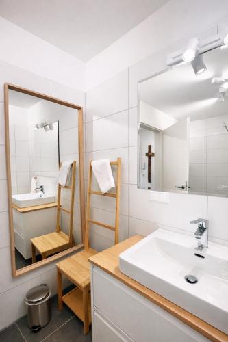 a bathroom with a sink and a mirror at Die Malerei Penthouse by Da Alois in Gröbming