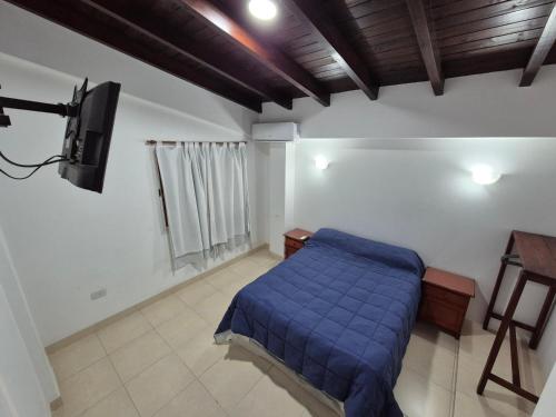 a bedroom with a blue bed and a television at Departamentos Blazu Cafayate in Cafayate