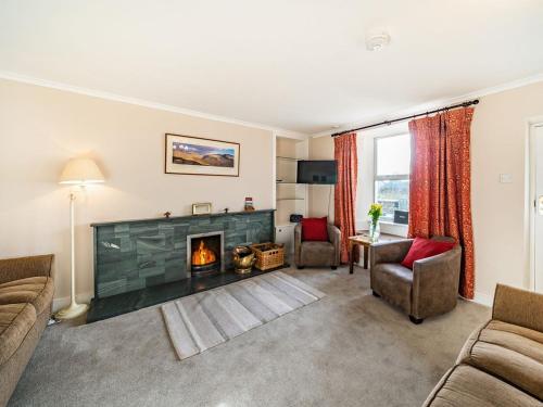 a living room with a fireplace and a couch and chairs at 2 Fairview Terrace Ambleside in Ambleside