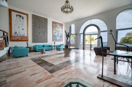 a living room with blue couches and a chandelier at Hotel y Museo Casa Turquesa in Cancún