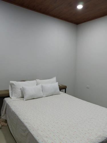 a white bedroom with a bed with white sheets and pillows at SJO - Casa Taccari in Grecia