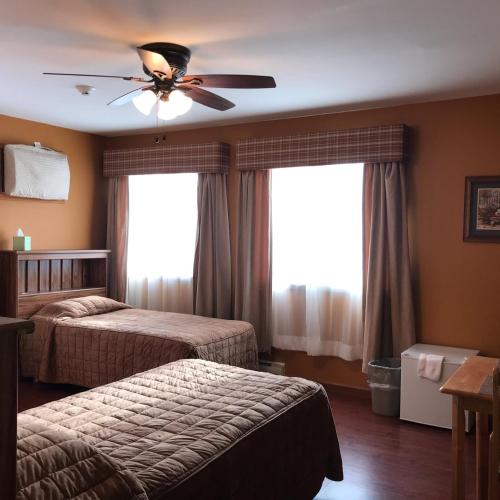 a bedroom with two beds and a ceiling fan at Trout Town Inn in Roscoe
