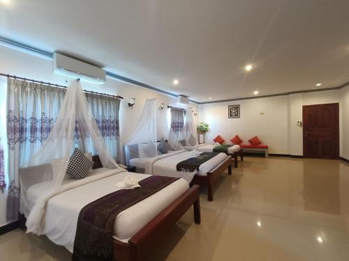 a hotel room with three beds in a room at Parent Heritage Angkor Villa in Siem Reap