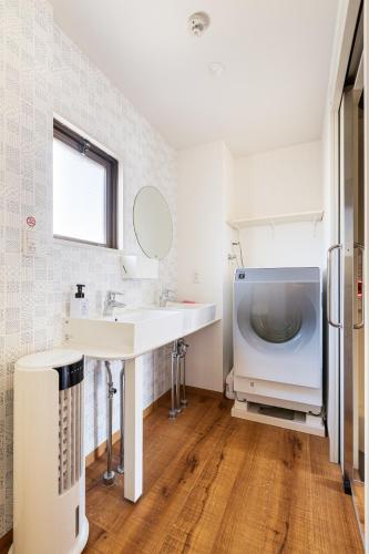 a bathroom with a sink and a washing machine at Guesthouse YOURS in Osaka