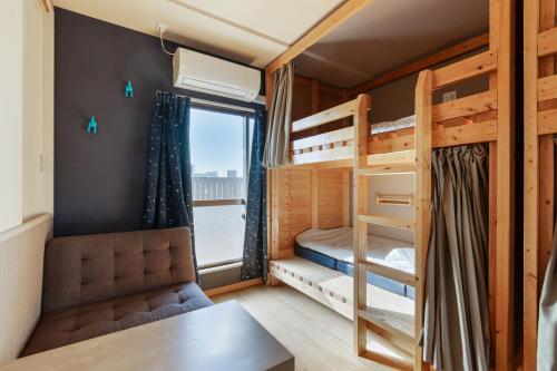 a dorm room with bunk beds and a desk at Guesthouse YOURS in Osaka
